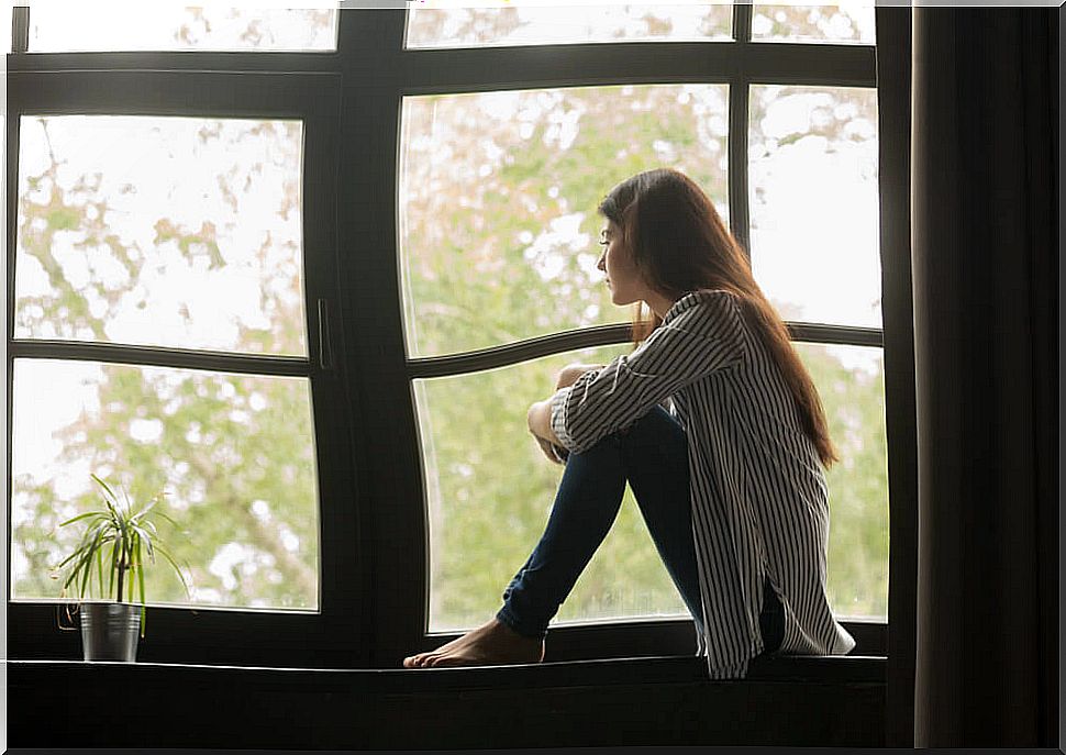 Teenager looking out the window during confinement.