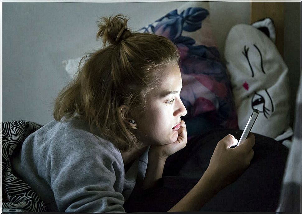 Teenager talking on the mobile with his friends during confinement,