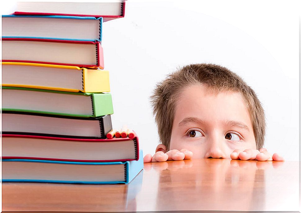 Scared child looking at a pile of books.