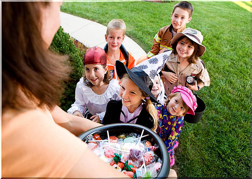 Children asking for candy in a house for Halloween.