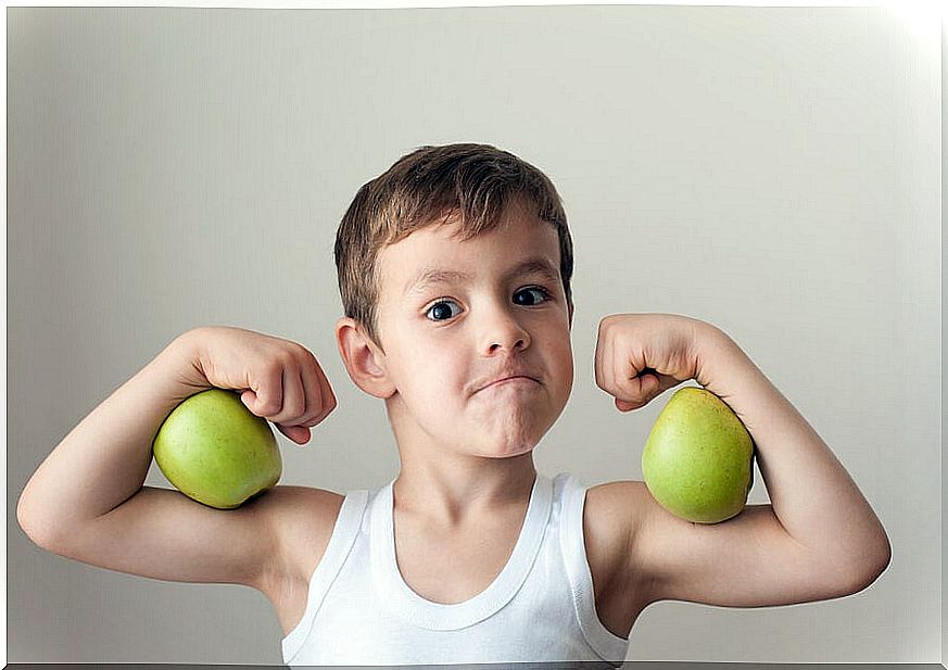 Boy with two apples for biceps as part of his healthy recess snacks.