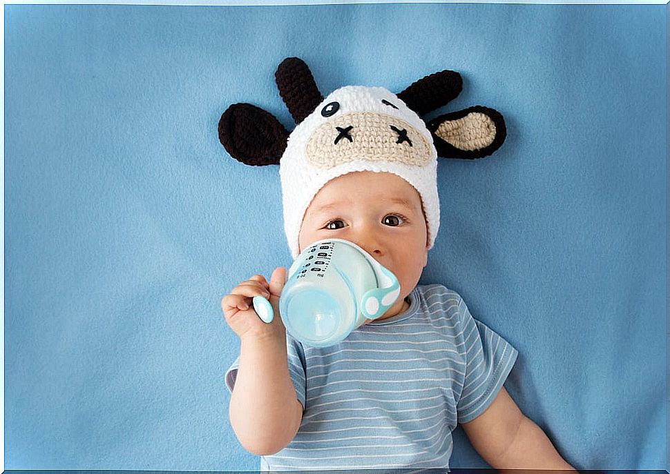 Baby drinking formula milk from a bottle.