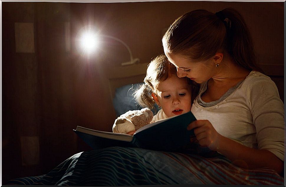 Mother reading a story to her daughter when last night because it is time to read.