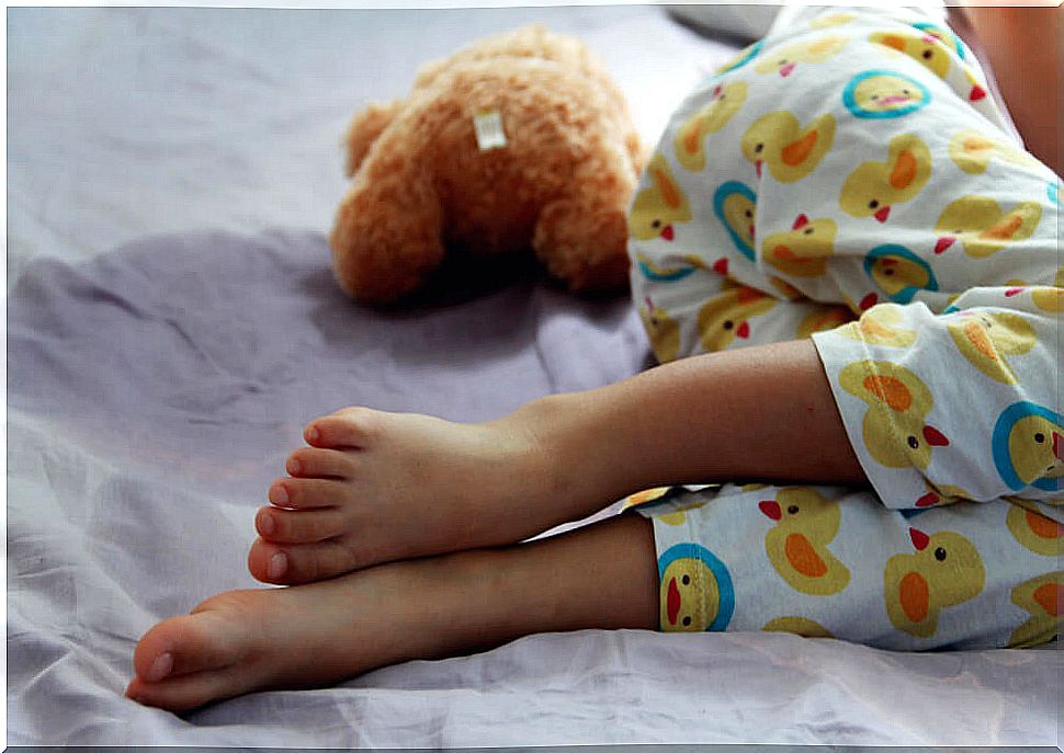 Child peeing in bed due to nocturnal enuresis.