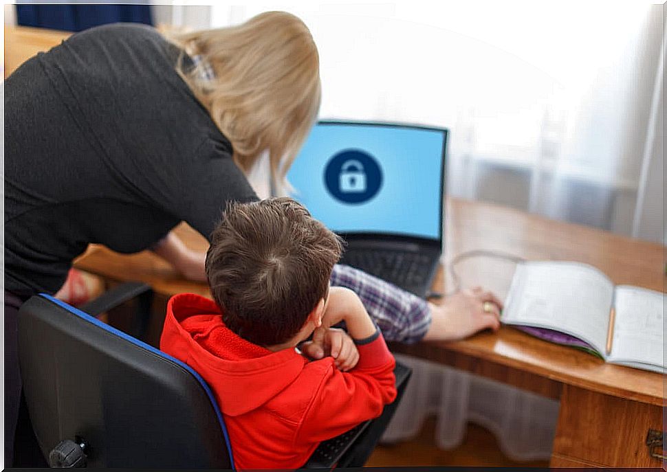 Mother applying parental control on her son's computer when studying.