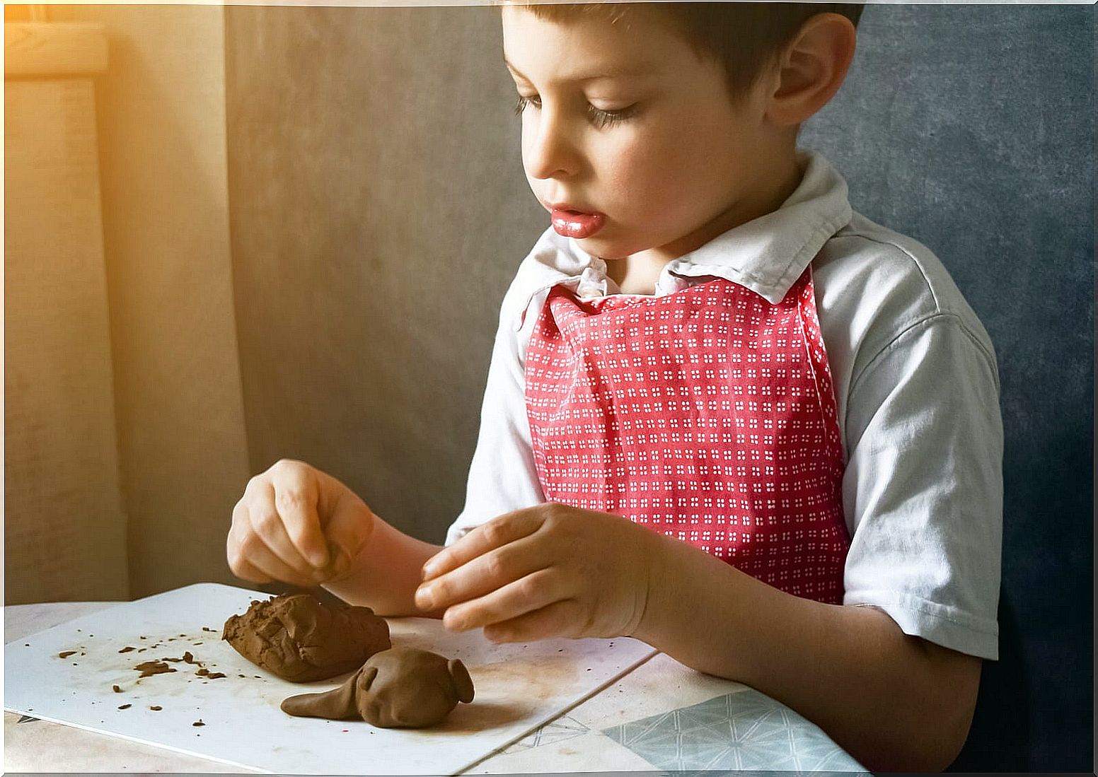 Child making figures with clay at home.