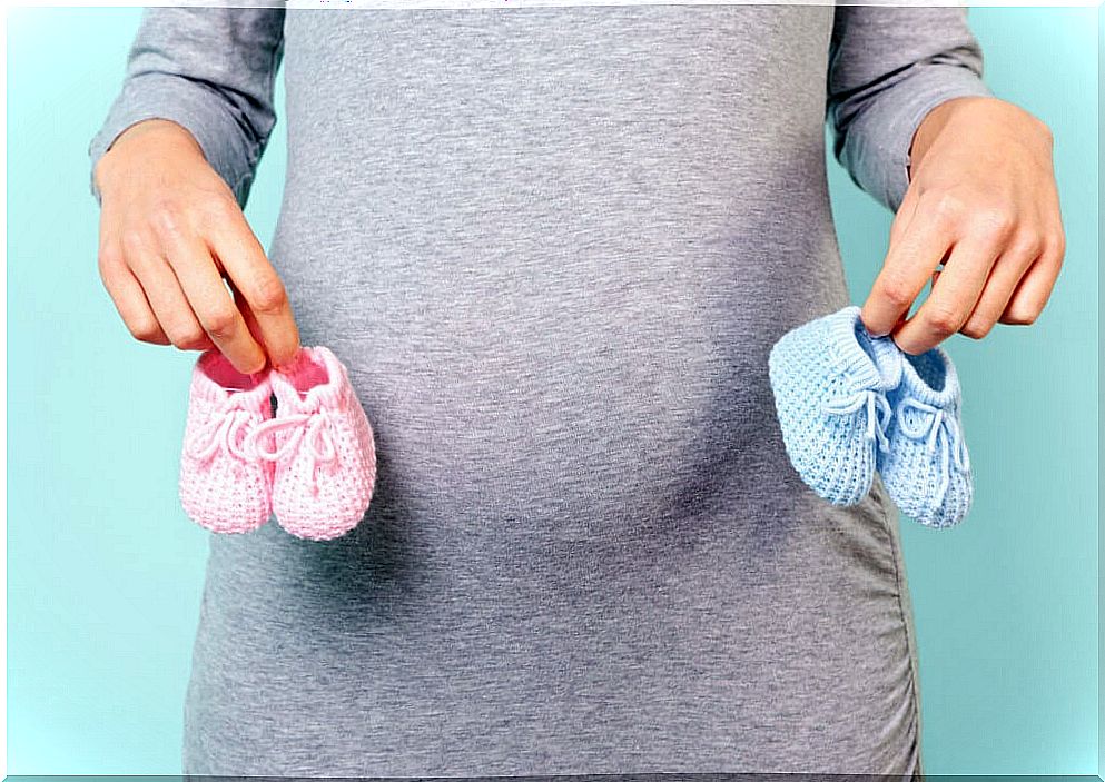 Pregnant woman holding baby booties