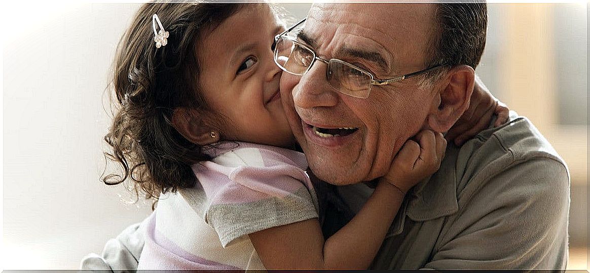 Granddaughter kisses her grandfather.