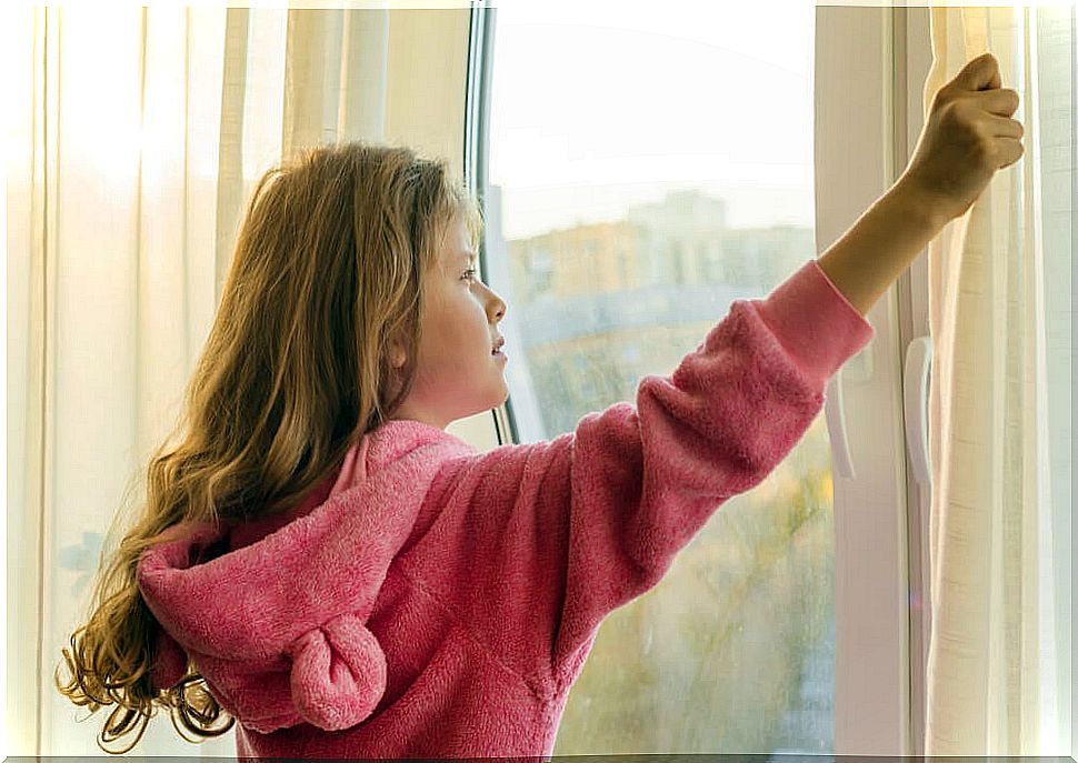 Girl looking out the window during quarantine.